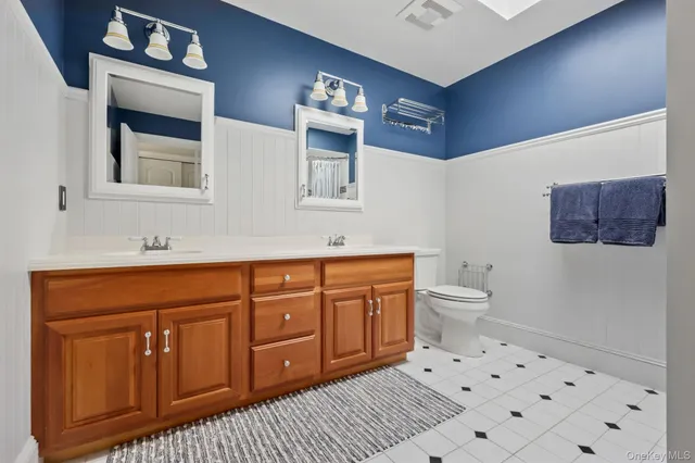 a spacious bathroom with a sink a toilet and a mirror