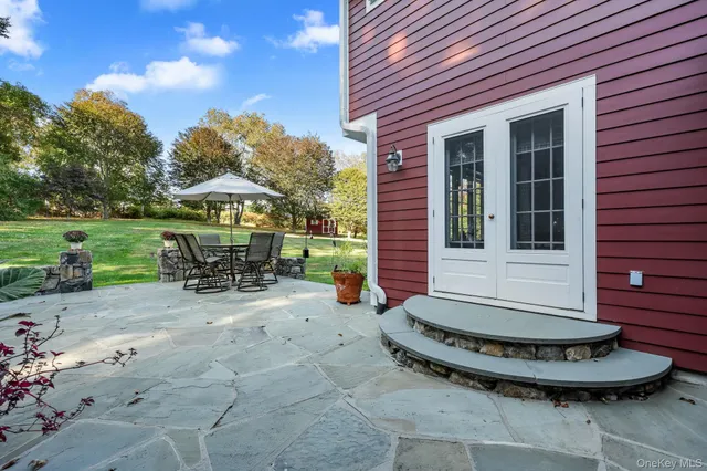 a view of a chair and table in backyard of the house