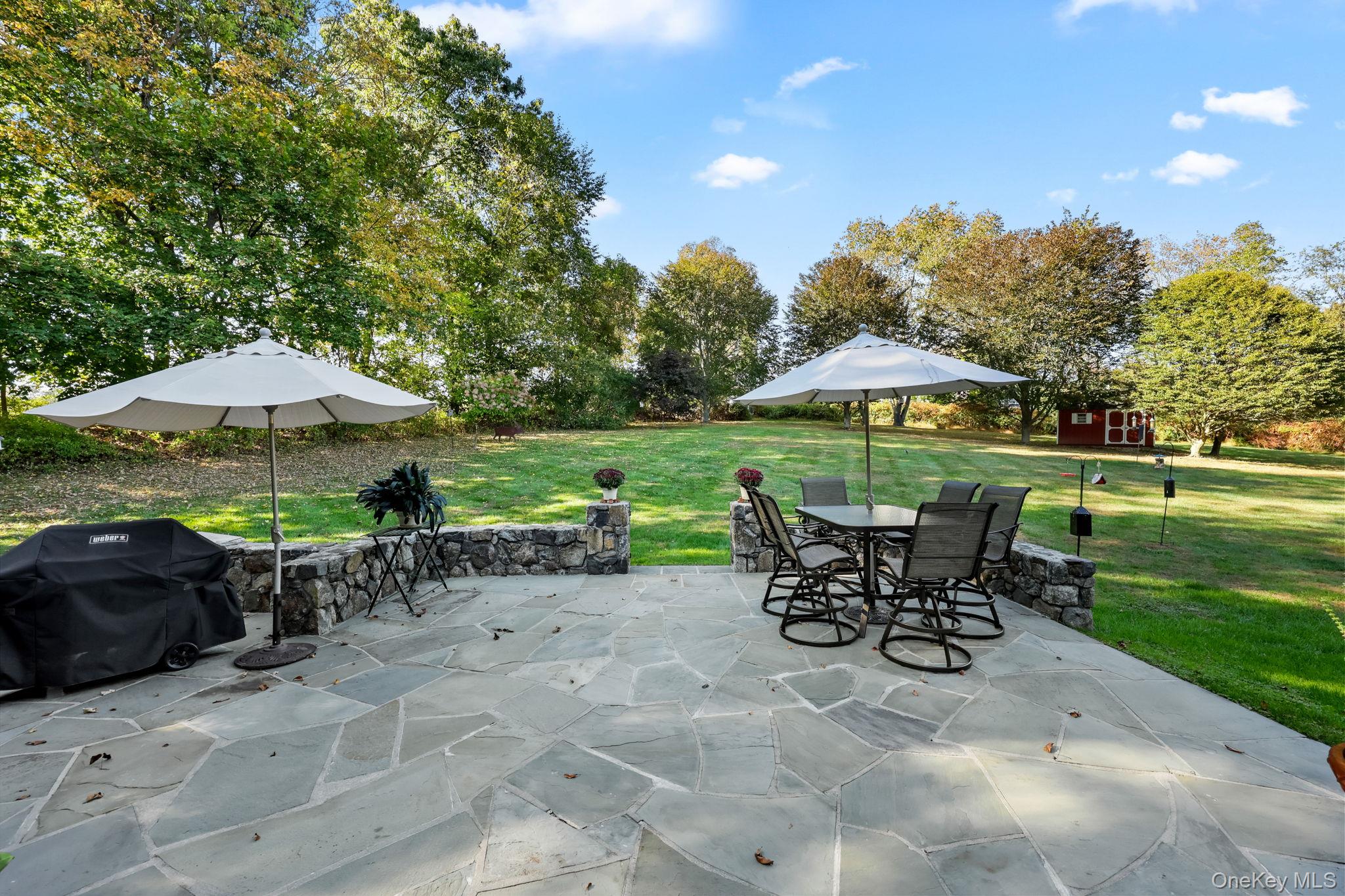 21 Adams Farm Road Katonah, NY 10536 - Photo 40 of 47 a view of a table and chairs under an umbrella in backyard