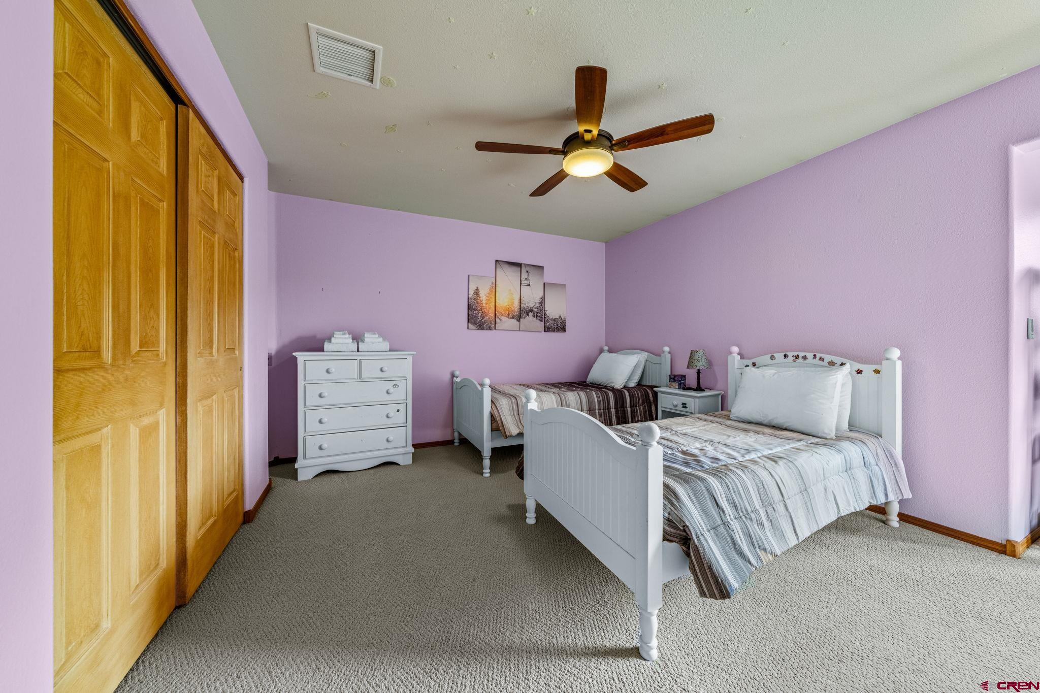 201 Ute Canyon Road Durango, CO 81301 - Photo 18 of 44 a bedroom with a bed and a chandelier