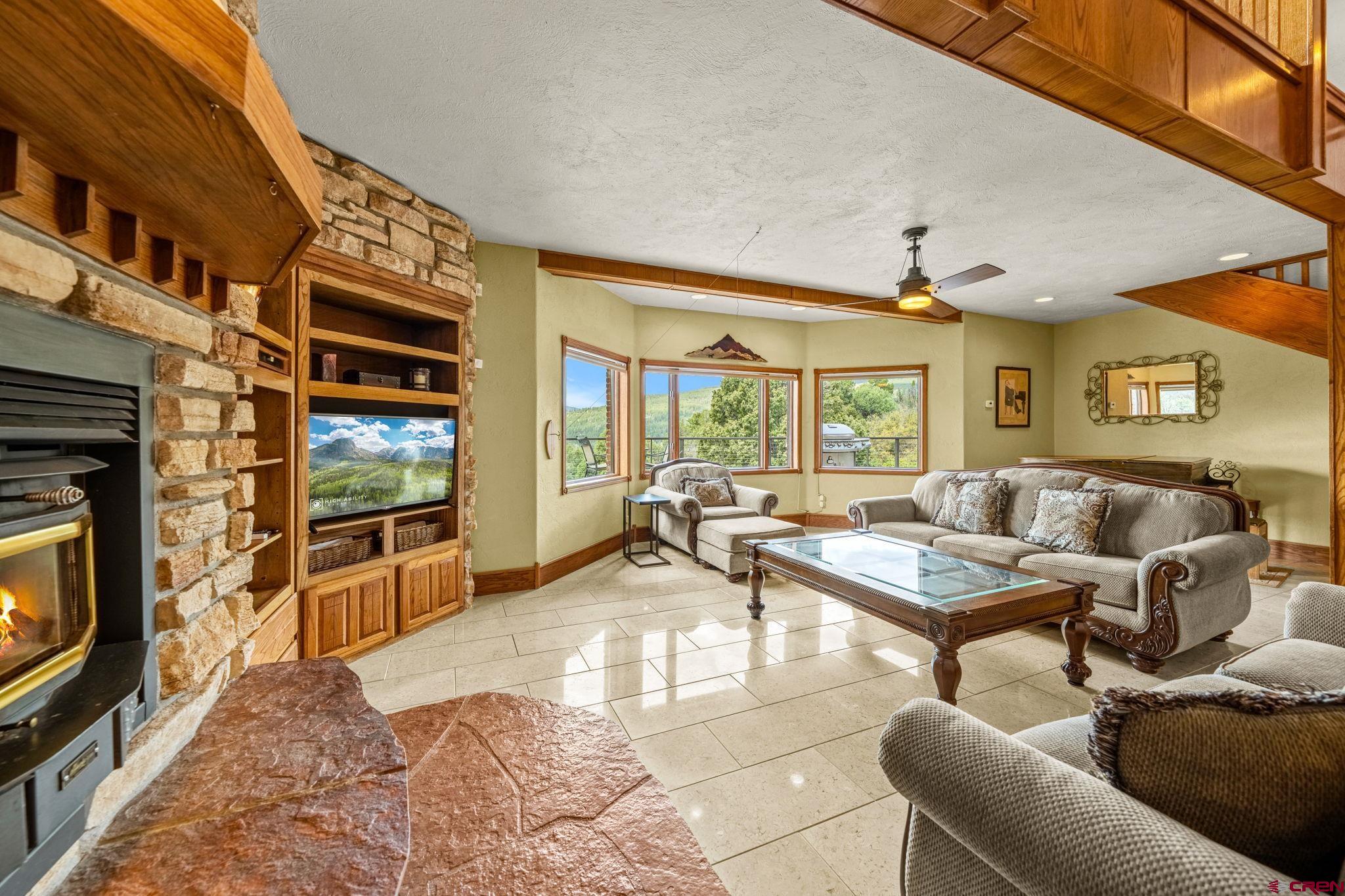 201 Ute Canyon Road Durango, CO 81301 - Photo 30 of 44 a living room with furniture a flat screen tv and a fireplace