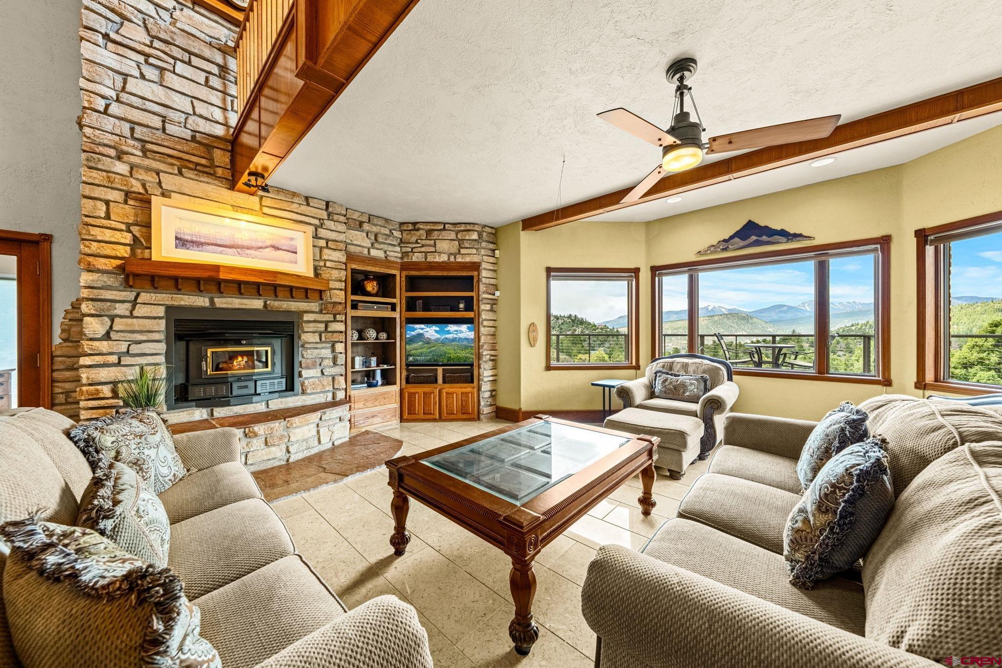 201 Ute Canyon Road Durango, CO 81301 - Photo 31 of 44 a living room with furniture large windows and a fireplace