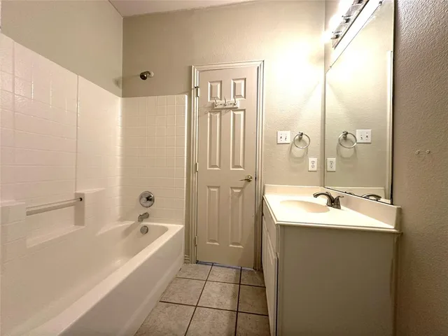 a bathroom with a tub sink and mirror