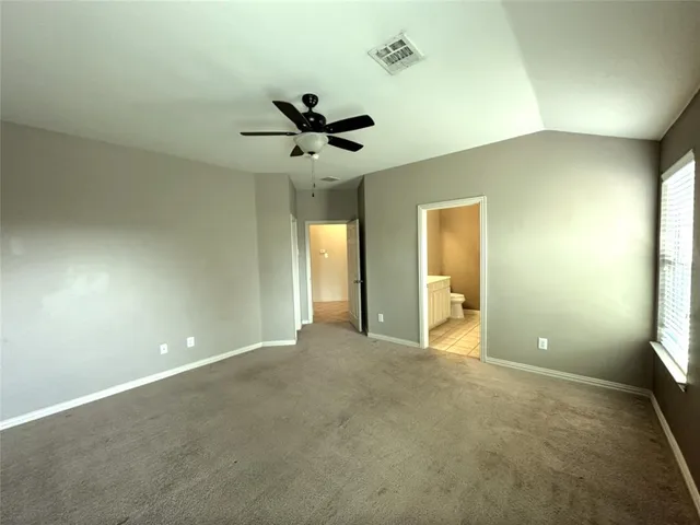a view of a big room with a ceiling fan and a window