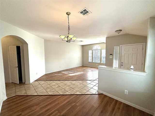 a view of a room with wooden floor and chandelier