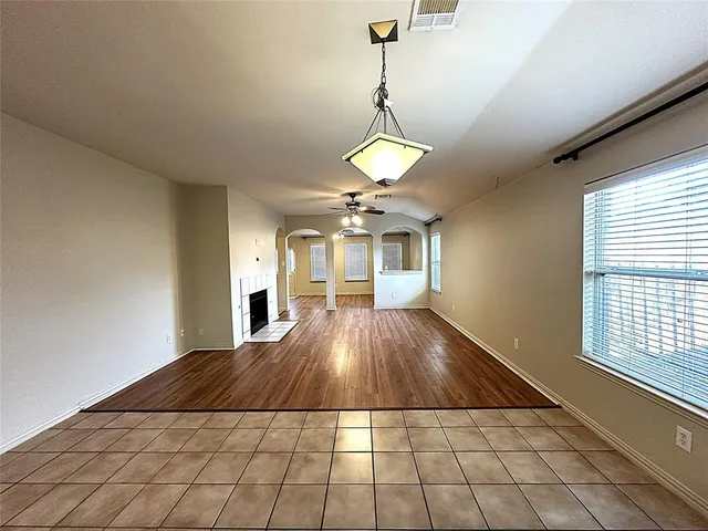 a view of a livingroom with a chandelier fan and windows