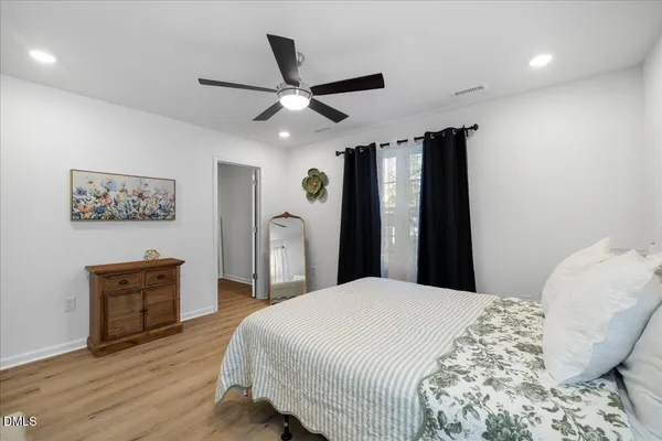 a bedroom with a bed and wooden floor