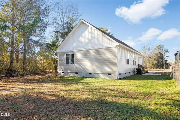 a view of a house with a big yard and large tree