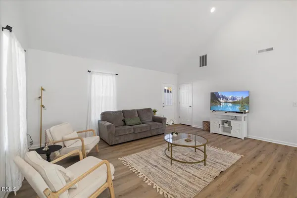 a living room with furniture and a wooden floor