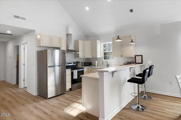 a kitchen with kitchen island a refrigerator a stove a sink and a refrigerator