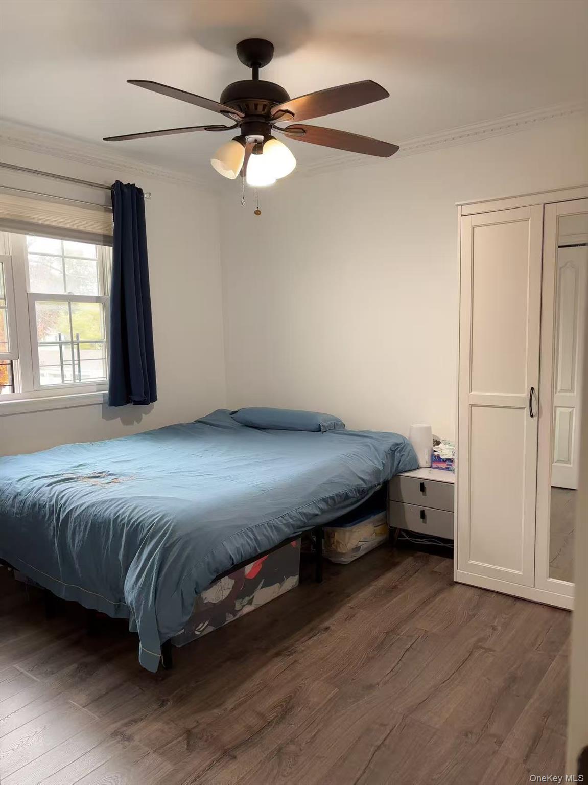 67-60 224 Street, Unit 6760A Queens, NY 11364 - Photo 11 of 12 a bedroom with a bed and a chandelier