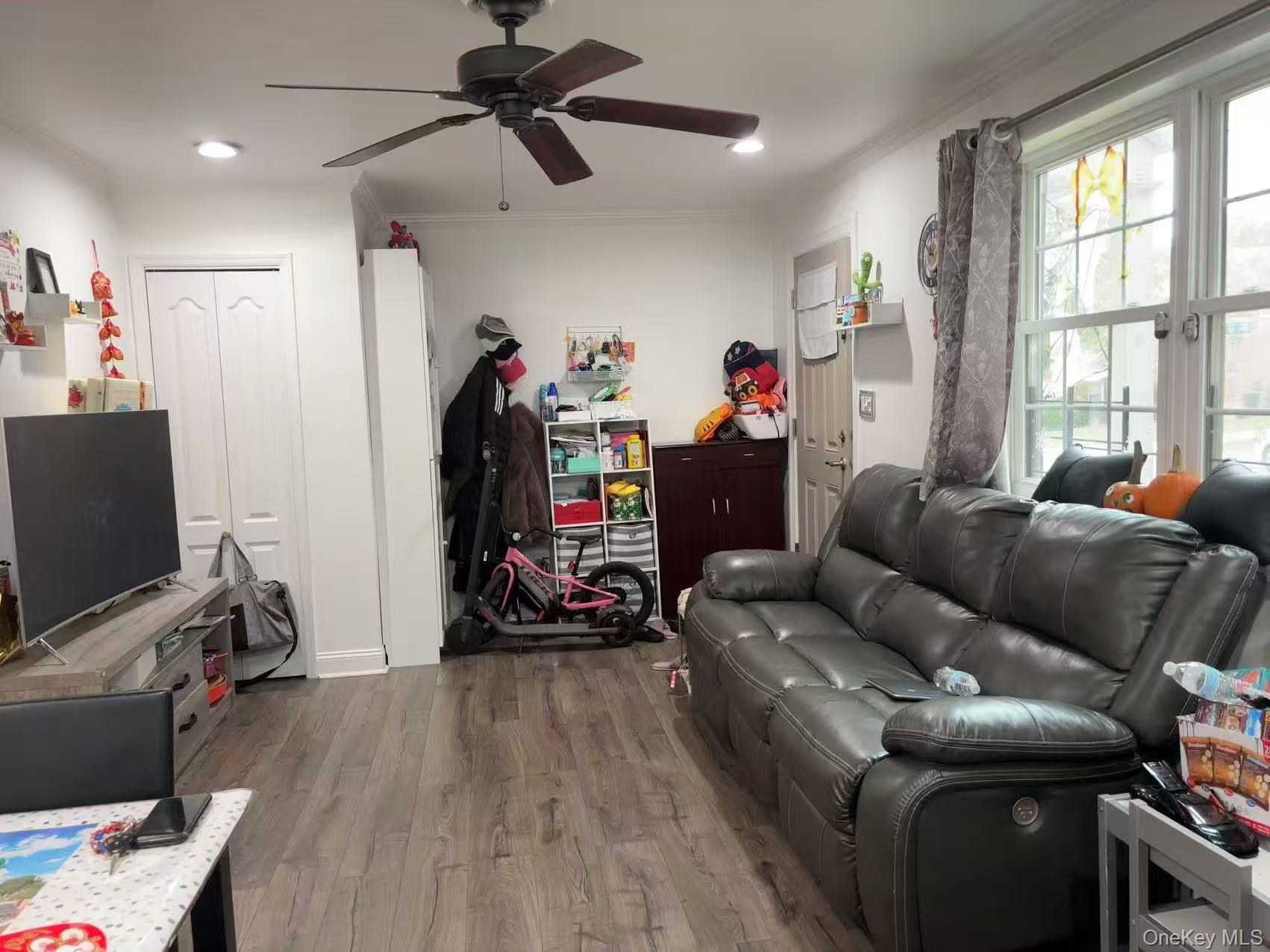 67-60 224 Street, Unit 6760A Queens, NY 11364 - Photo 2 of 12 a living room with furniture and a flat screen tv