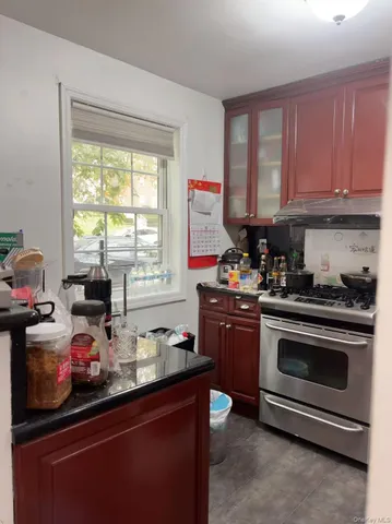 a kitchen with a stove a sink and a window