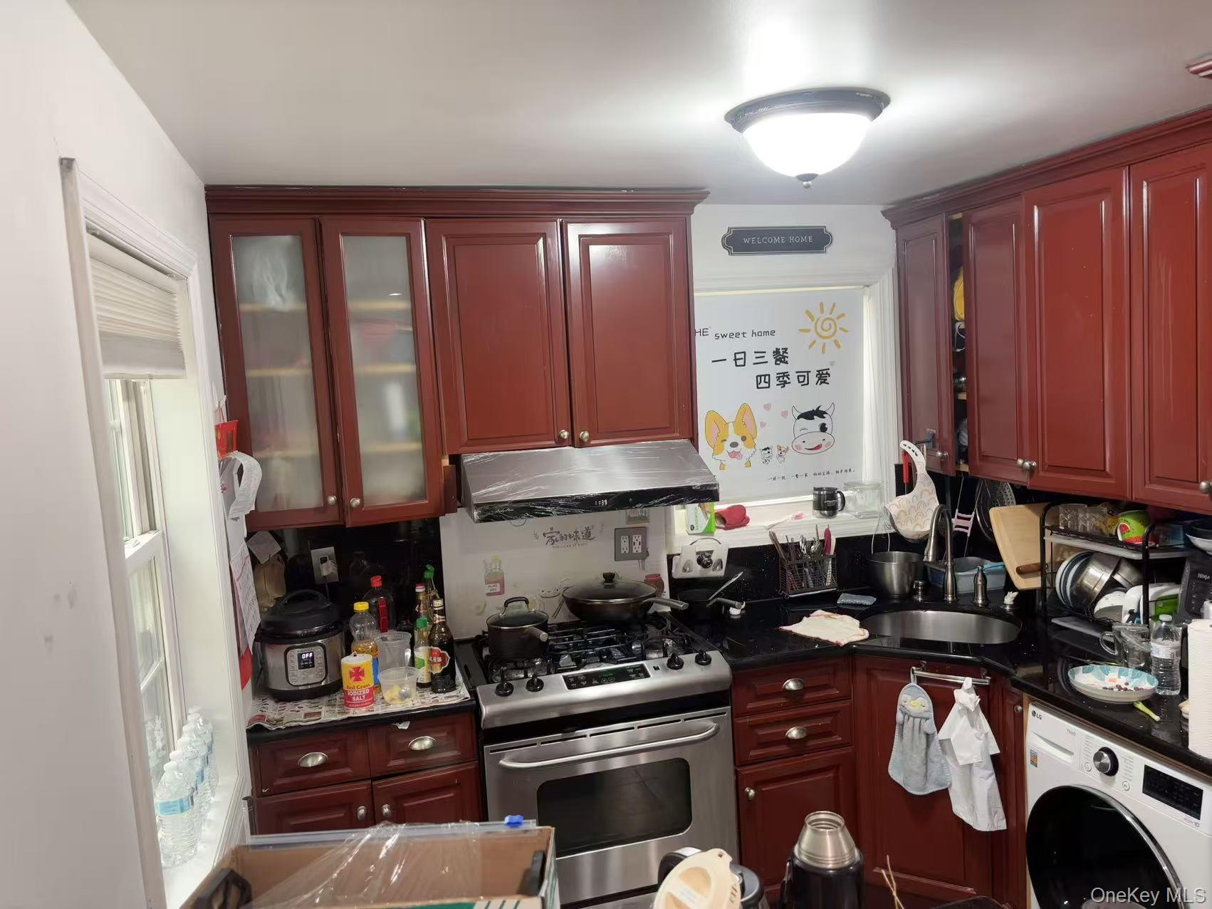 67-60 224 Street, Unit 6760A Queens, NY 11364 - Photo 5 of 12 a kitchen with stainless steel appliances granite countertop a stove a sink and a refrigerator