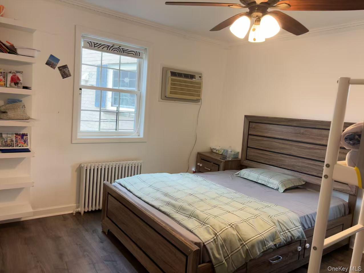 67-60 224 Street, Unit 6760A Queens, NY 11364 - Photo 7 of 12 a bedroom with a bed and a window