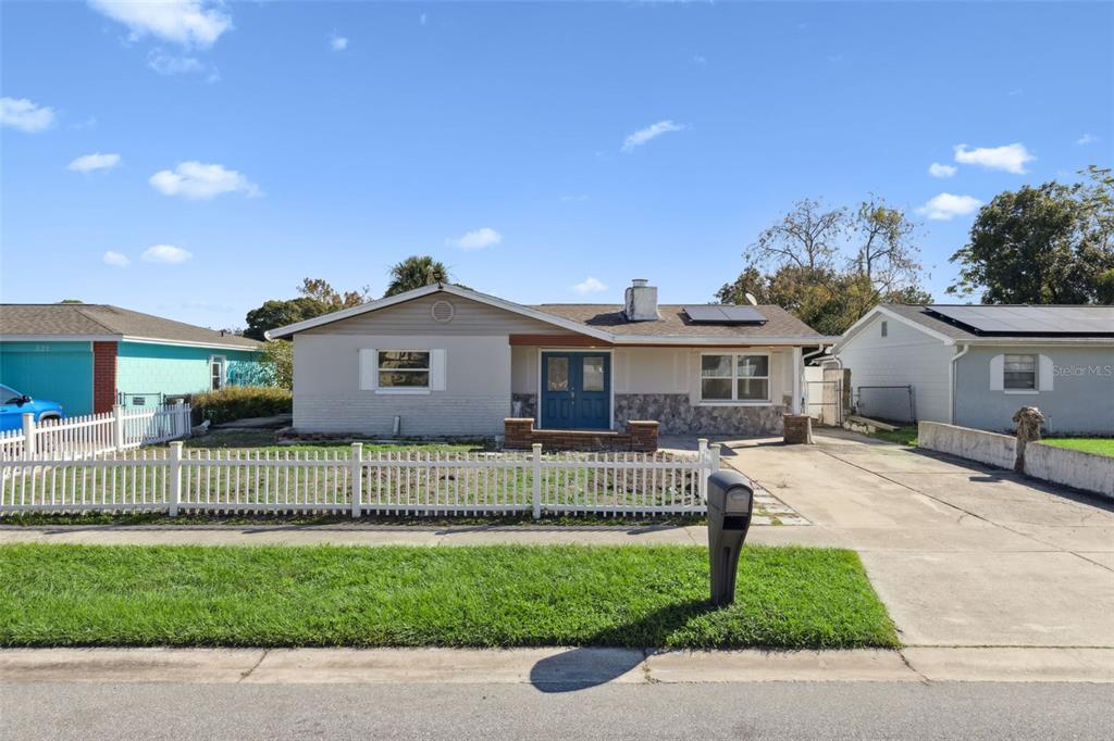 a front view of a house with a garden and plants