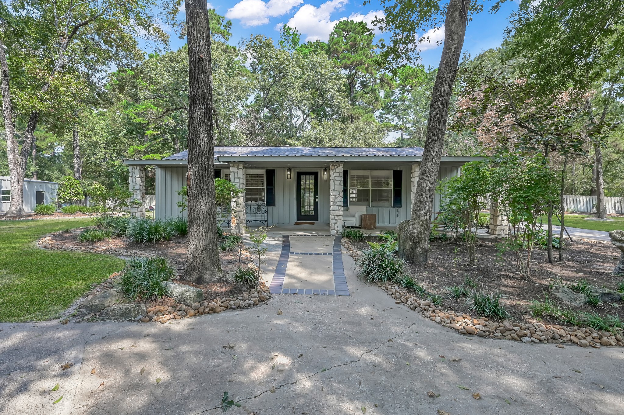 3272 Teas Nursery Road Conroe, TX 77304 - Photo 33 of 50 a view of house in front of a yard with potted plants and large trees