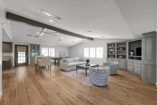 a living room with furniture a table and kitchen view