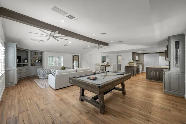 a kitchen with stainless steel appliances granite countertop a table chairs stove and cabinets