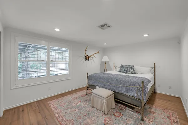 a bedroom with a large bed and wooden floor
