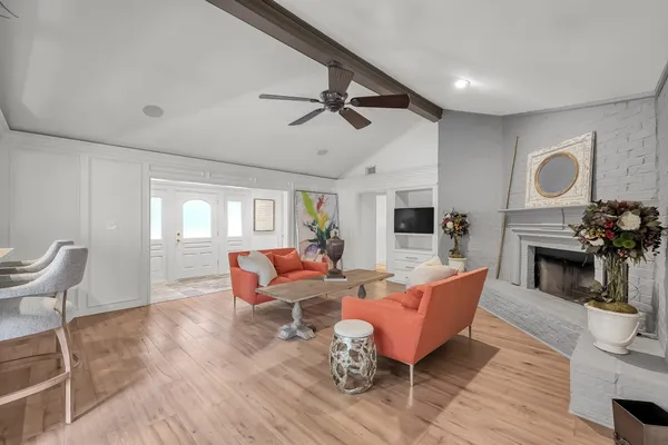 a dining room with furniture a chandelier and wooden floor