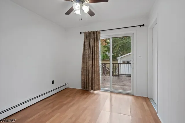 en empty room with wooden floor and windows
