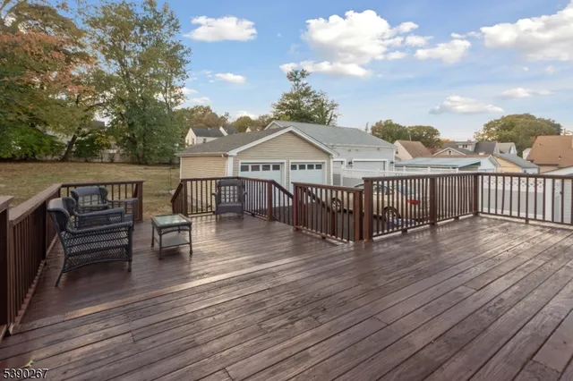 a view of a house with wooden deck and furniture