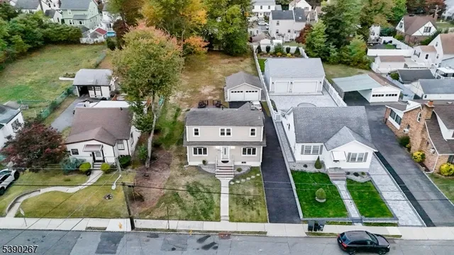 an aerial view of residential houses with outdoor space and parking