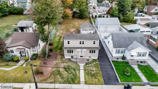 an aerial view of a house with swimming pool and large trees