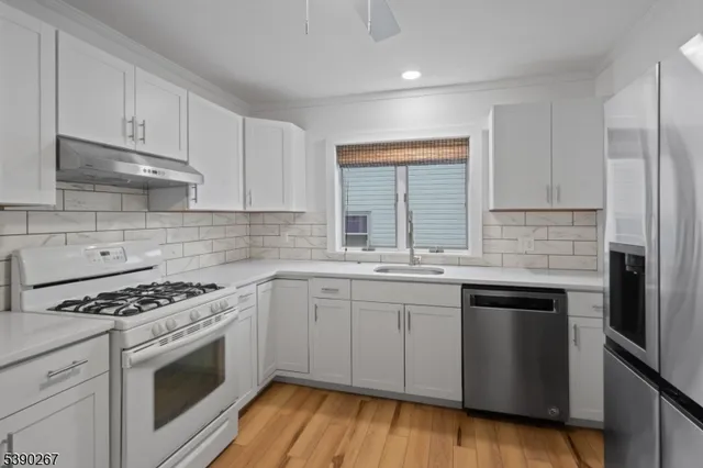 a kitchen with granite countertop a sink stove and cabinets