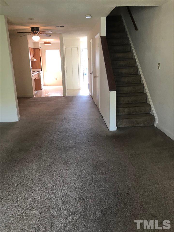 2506 Avent Ferry Road, Unit 203 Raleigh, NC 27606 - Photo 8 of 13 a view of an empty room with wooden floor and stairs