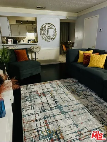 a bedroom with a bed and a lamp on dresser