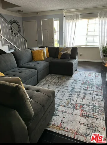 a living room with furniture and a floor to ceiling window