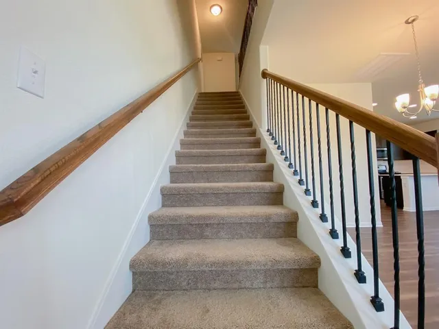 a view of staircase with lots of frames on wall