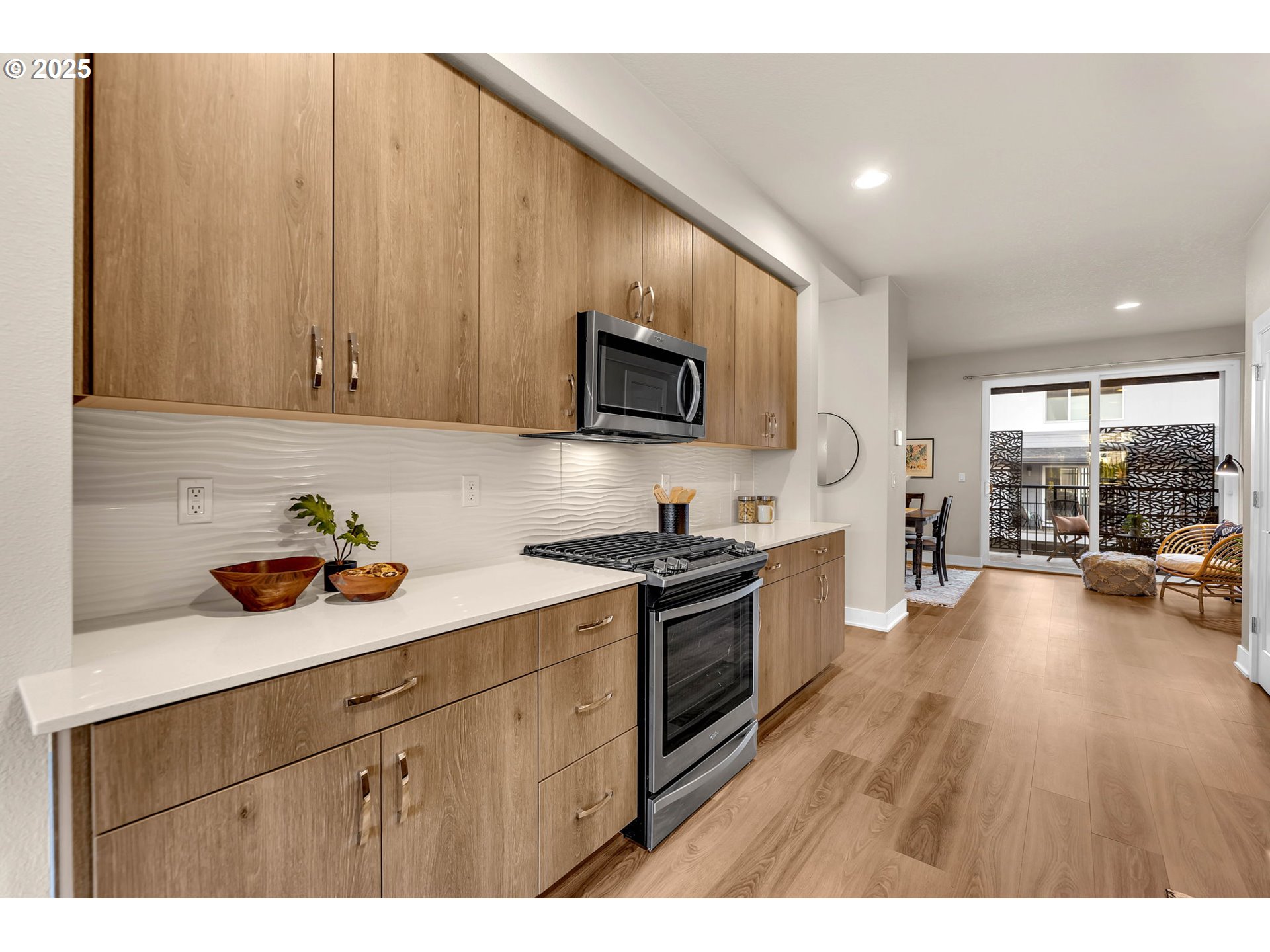 17238 Southwest Goldcrest Lane Beaverton, OR 97007 - Photo 16 of 48 a kitchen with stainless steel appliances granite countertop a stove a sink dishwasher and a microwave with wooden floor