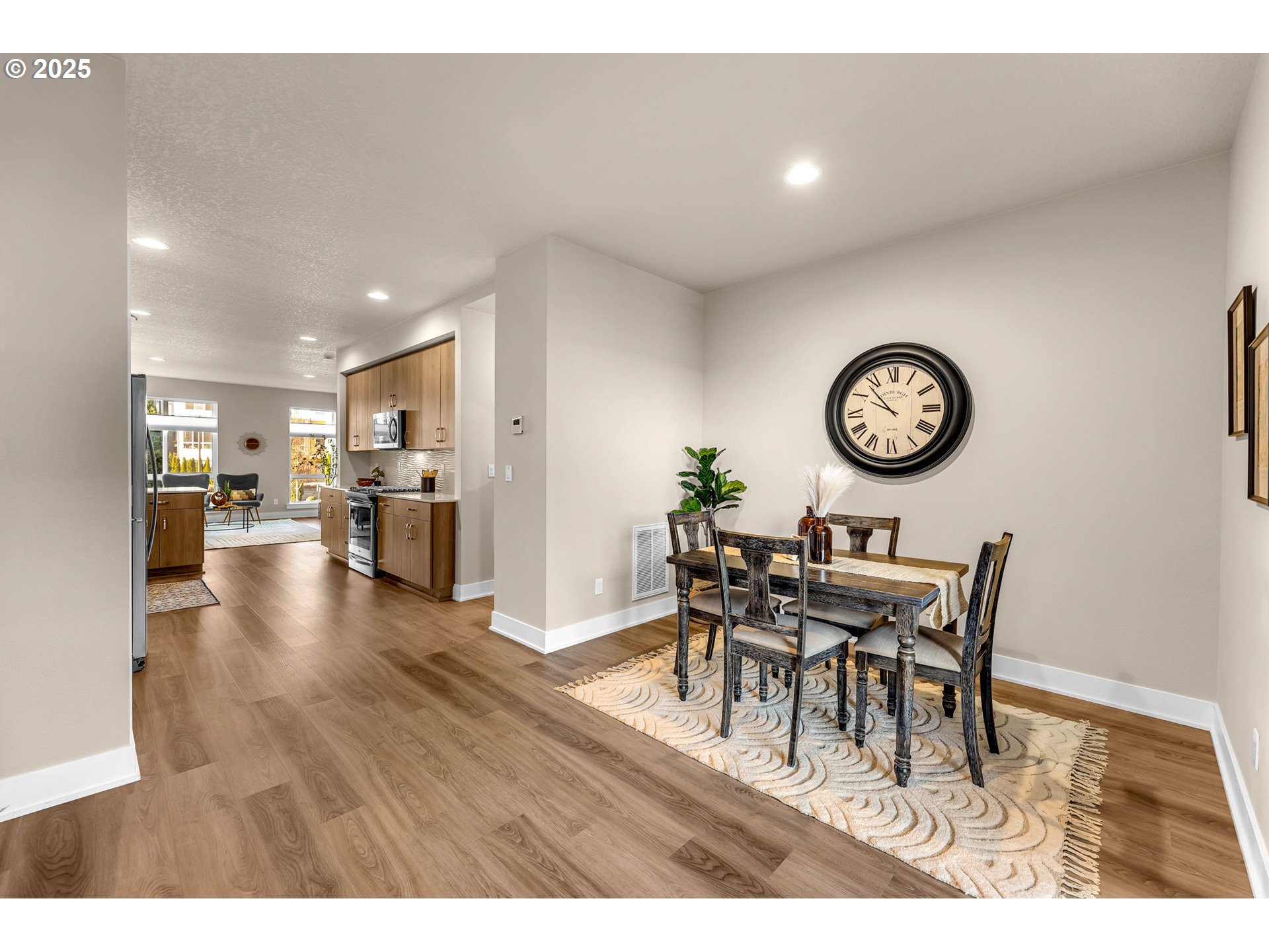 17238 Southwest Goldcrest Lane Beaverton, OR 97007 - Photo 27 of 48 a view of a dining room and livingroom with furniture wooden floor and a clock