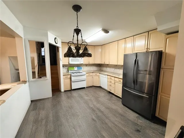 a kitchen with stainless steel appliances a refrigerator and wooden floor