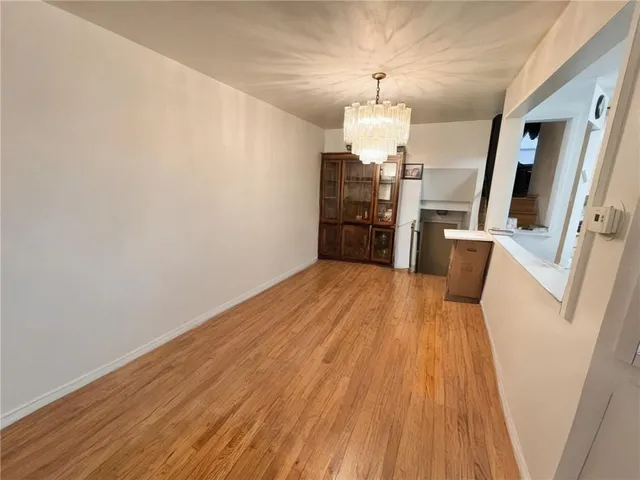 a view of a room with wooden floor and chandelier
