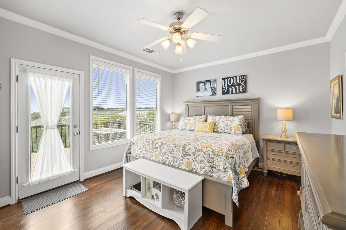 218 Sunrise Ridge Loop Lakeway, TX 78738 - Photo 14 of 40 a bedroom with a large bed and a chandelier