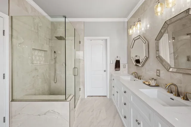 a bathroom with a double vanity sink mirror and bathtub