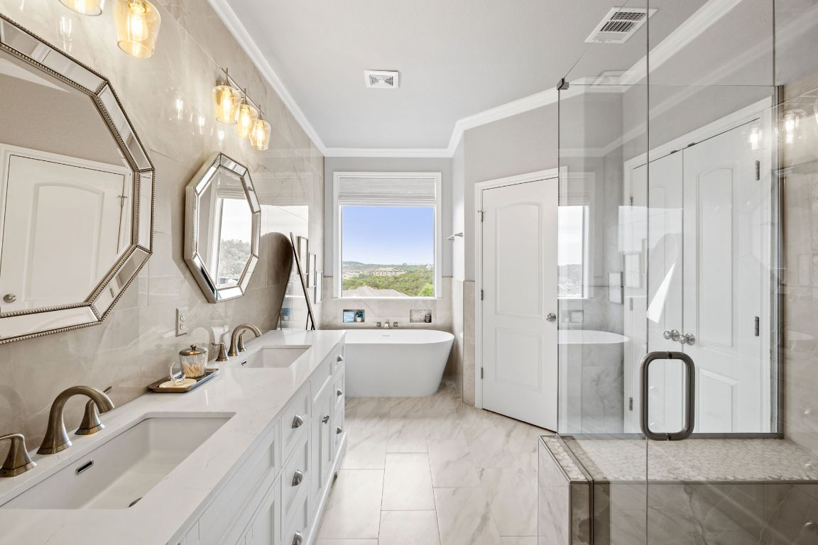 218 Sunrise Ridge Loop Lakeway, TX 78738 - Photo 19 of 40 a bathroom with a double vanity sink mirror and bathtub
