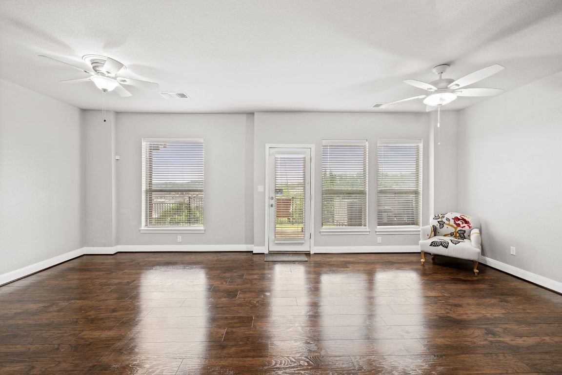 218 Sunrise Ridge Loop Lakeway, TX 78738 - Photo 29 of 40 a view of a livingroom with wooden floor a ceiling fan and windows