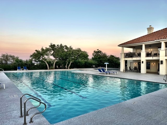 218 Sunrise Ridge Loop Lakeway, TX 78738 - Photo 39 of 40 Pool at dusk featuring a community pool and a patio area