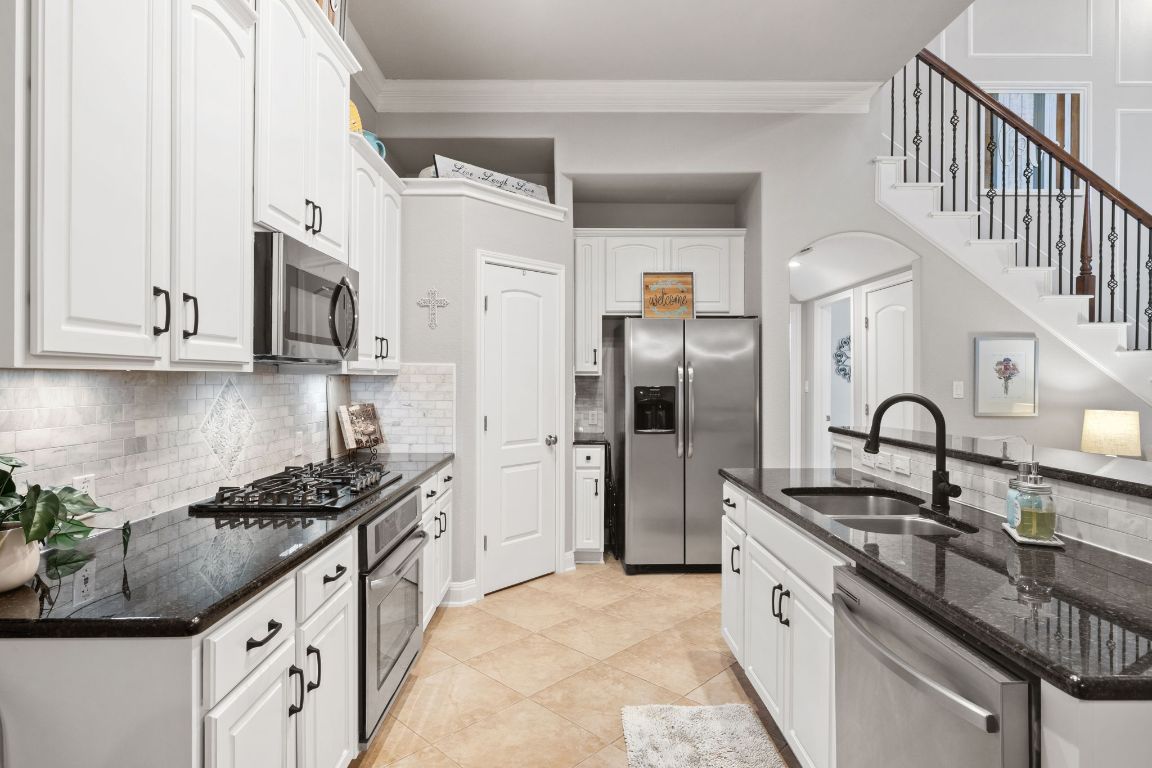 218 Sunrise Ridge Loop Lakeway, TX 78738 - Photo 6 of 40 Kitchen featuring large walk-in pantry, granite countertops and customer backsplash.