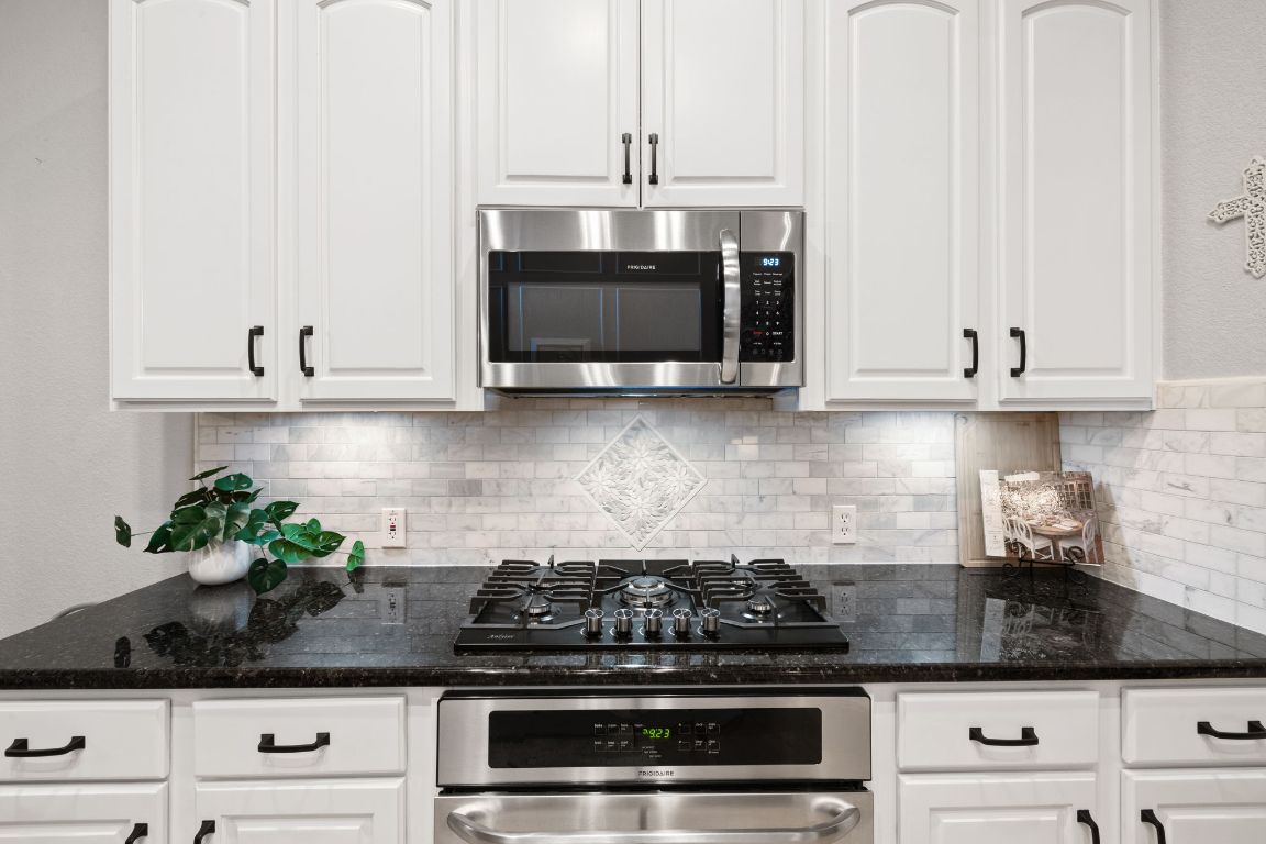 218 Sunrise Ridge Loop Lakeway, TX 78738 - Photo 8 of 40 Kitchen featuring white cabinets, backsplash, and appliances with stainless steel finishes
