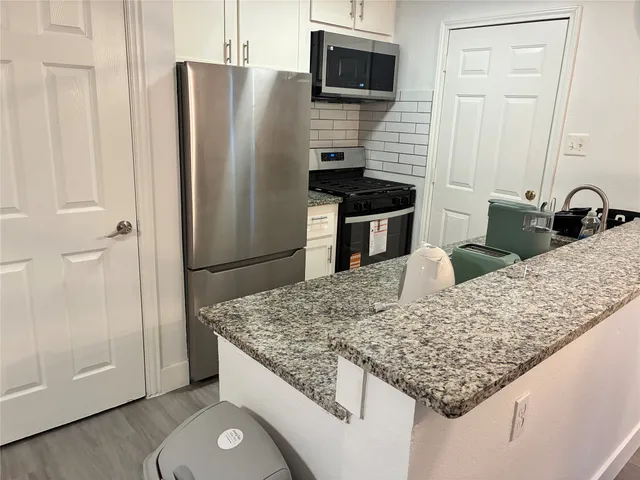a kitchen with stainless steel appliances granite countertop a refrigerator oven a sink and dishwasher