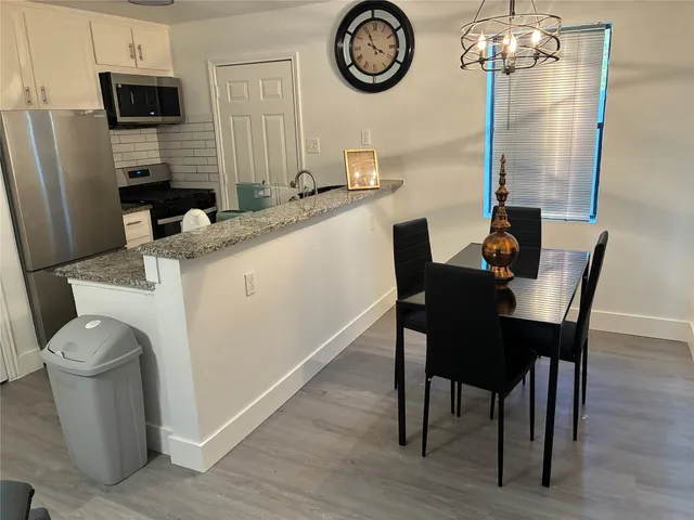 a kitchen with a table chairs and a refrigerator