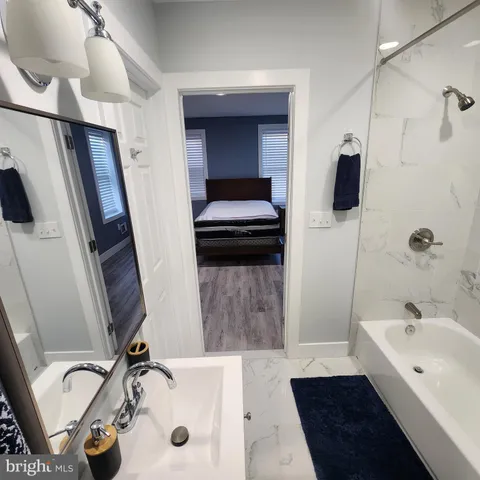a bathroom with a tub a sink and a mirror
