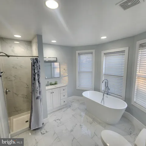 a bathroom with a granite countertop sink toilet and shower