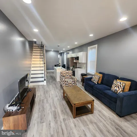 a living room with furniture and a wooden floor